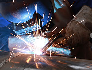 welder is welding big pipe with all safety